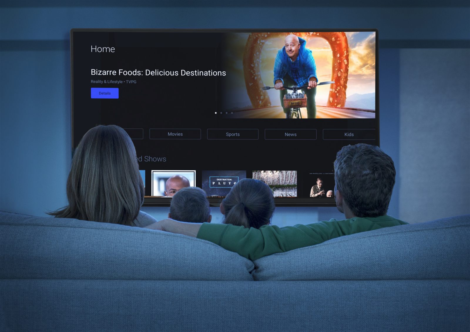 Family watching TV together on a couch in a rental living room